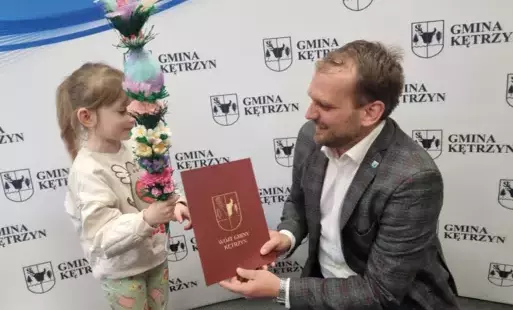 Na zdjeciu wójt wręcza dyplom młodej laureatce konkursu